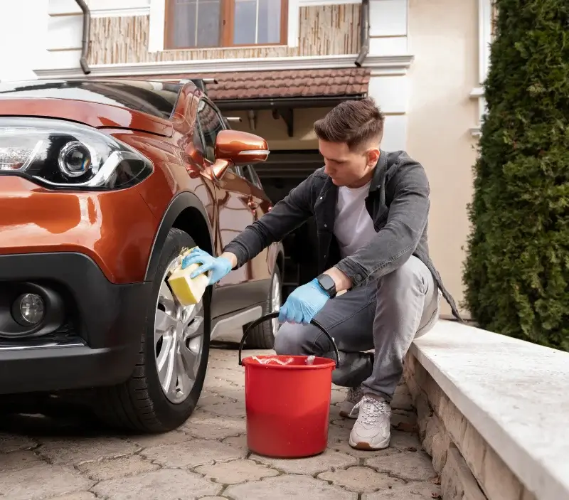 Lavage auto à domicile Le Bélieu : professionnel intervenant sur un véhicule